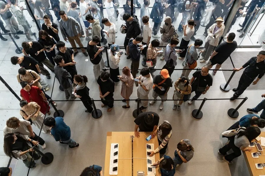 Customers queue to collect their pre-ordered purchases at the Apple Inc. Sanlitun store in Beijing, China, on 18 September 2026.