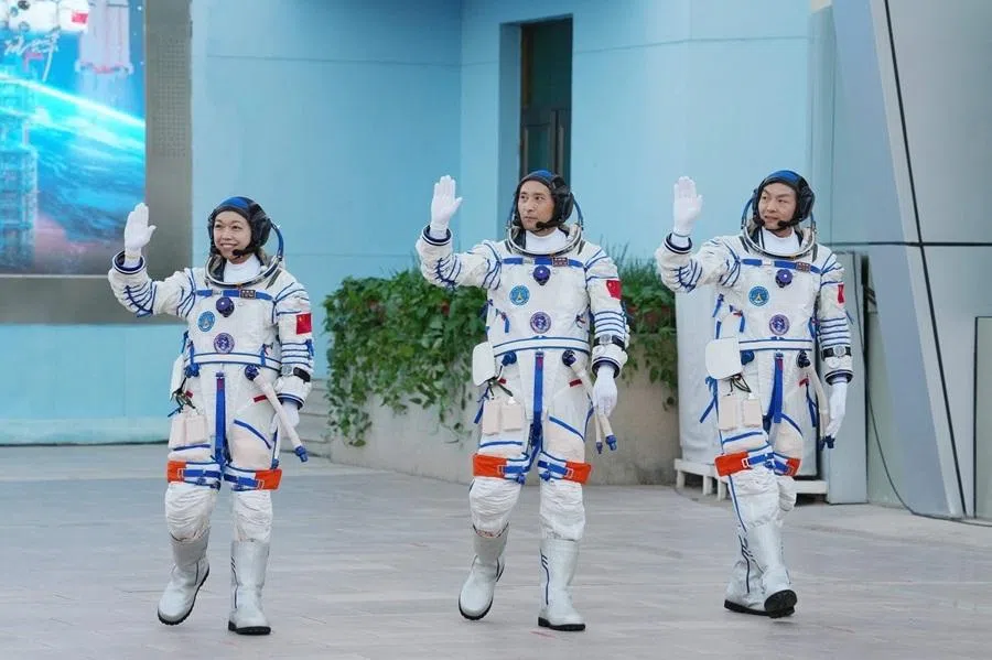 Astronauts for China's Shenzhou-23 space mission Li Jiaying, Zhu Yangzhu, and Zhang Zhiyuan, wave during a departure ceremony before boarding a bus to take them to the spaceship at the Jiuquan Satellite Launch Centre in the Gobi desert in northwest China on 24 May 2025.