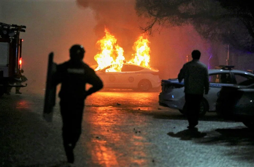 A view shows a burning police car during a protest against LPG cost rise following the Kazakh authorities' decision to lift price caps on liquefied petroleum gas in Almaty, Kazakhstan, 5 January 2022. (Pavel Mikheyev/Reuters)