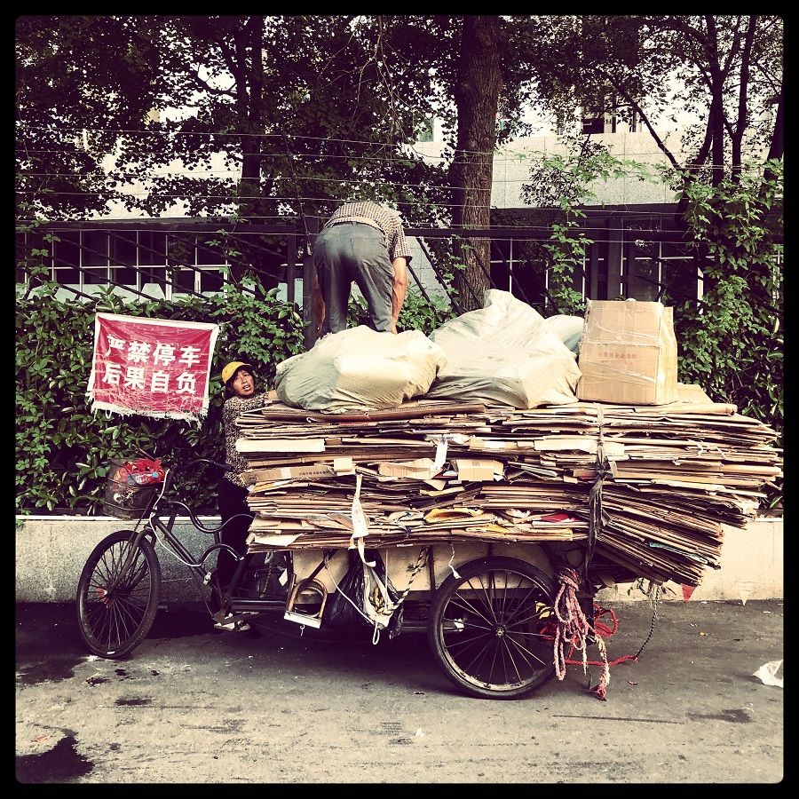 A couple packing their tricycle high with discarded cardboard in Changning, Shanghai. They are an all too familiar scene in many cities in China.