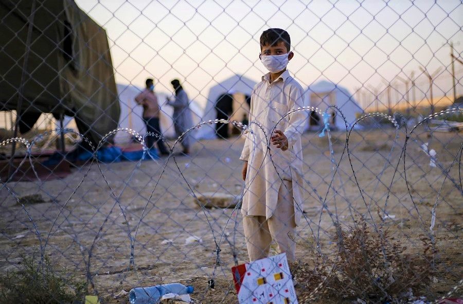 A handout picture made available by the Iranian Red Crescent on 19 August 2021, shows a young Afghan refugee at the Iran-Afghanistan border between Afghanistan and the southeastern Iranian Sistan and Baluchestan province, as people fleeing AFghanistan try to enter the Islamic republic following the takeover of their country by the Taliban earlier this week. (Mohammad Javadzadeh/Iranian Red Crescent/AFP)