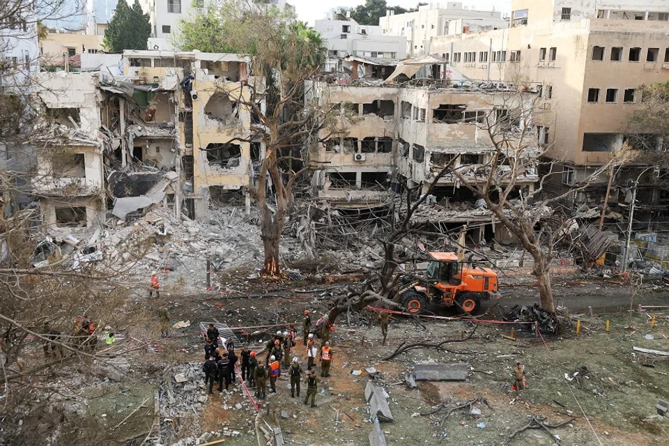 Emergency personnel work at an impact site after missiles were launched from Iran to Israel, in Tel Aviv, Israel, on 16 June 2025. (Ronen Zvulun/Reuters)