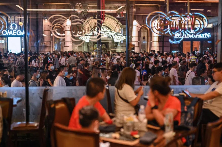 People walk along a pedestrian street during China's national day marking the 72nd anniversary of the establishment of the People's Republic of China and the country's "Golden Week" holiday in Shanghai on 1 October 2021. (Hector Retamal/AFP)