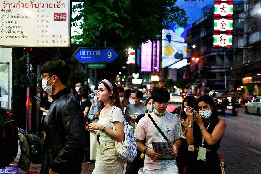 People stand in a queue outside a restaurant along the popular Yaowarat Road in the Chinatown area of Bangkok, Thailand, on 5 September 2022. (Manan Vatsyayana/AFP)