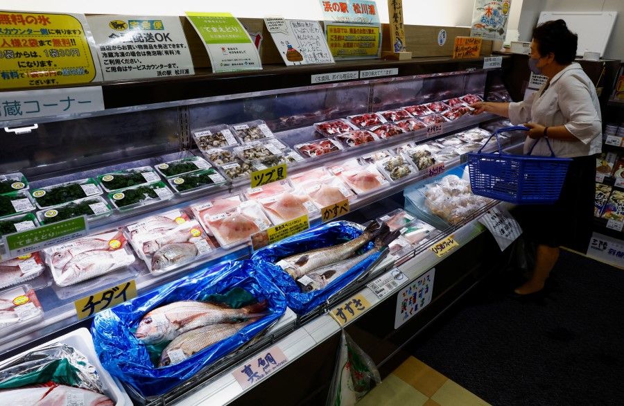 A customer browses through locally caught seafood at the Hamanoeki Fish Market and Food Court in Soma, Fukushima Prefecture, Japan, 31 August 2023. (Kim Kyung-Hoon/Reuters)