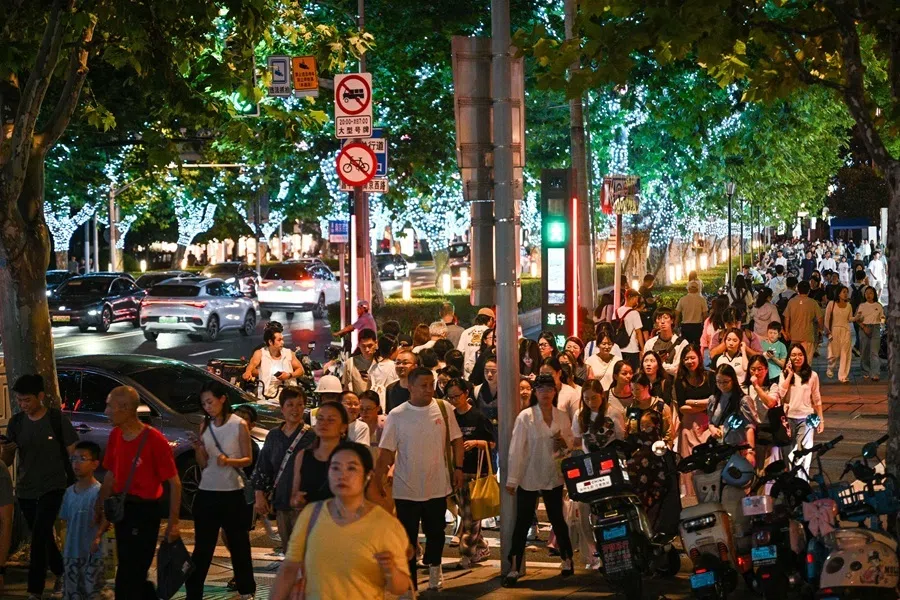 People walk on a street in the Jing' an district in Shanghai on 18 August 2026.