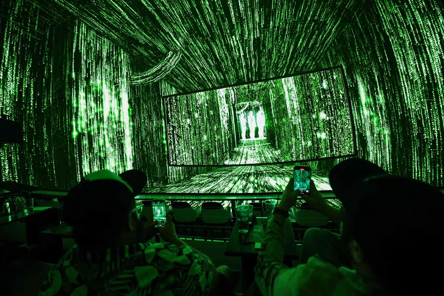 Attendees watch immersive computer code appear during the first shared reality screening of the movie The Matrix on an immersive dome screen inside Cosm Los Angeles at Hollywood Park in Inglewood, California, on 28 May 2025. (Patrick T. Fallon/AFP)