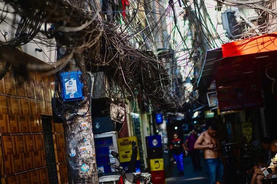 A pole with illegal power and telephone connections is pictured in an alleyway on the Rocinha favela, Rio de Janeiro, Brazil, on 18 November 2024. (Tercio Teixeira/AFP)