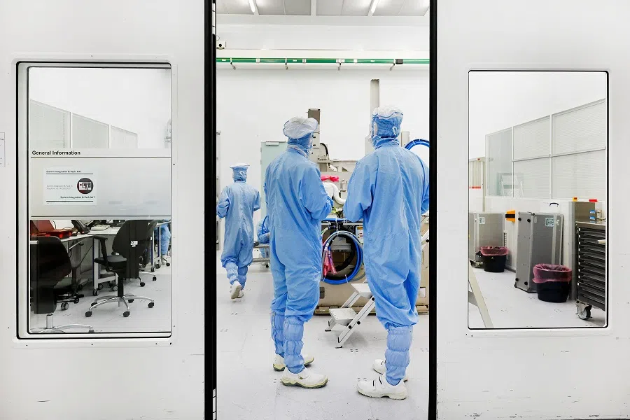 Assembly engineers work on a TWINSCAN DUV lithography system at ASML in Veldhoven, the Netherlands, 16 June 2023. (Piroschka van de Wouw/Reuters)