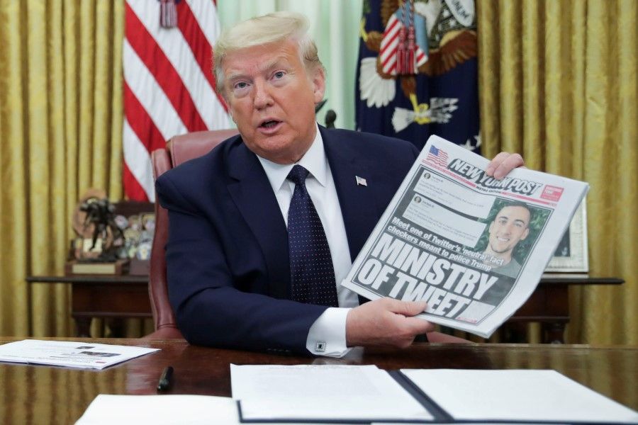 U.S. President Donald Trump holds up a front page of the New York Post as he speaks to reporters while signing an executive order on social media companies in the Oval Office of the White House in Washington, 28 May 2020. (Jonathan Ernst/REUTERS)