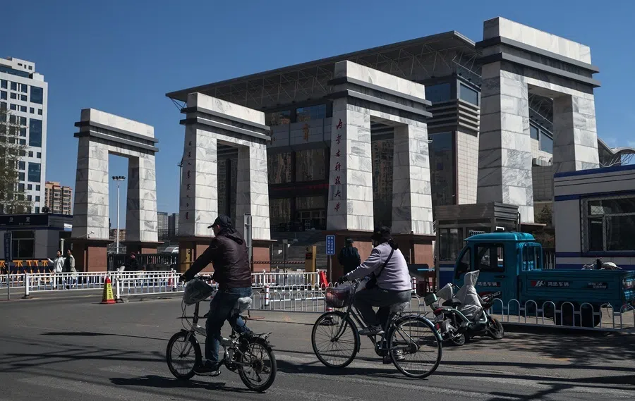 People ride bicycles by the entrance to the Inner Mongolia University of Science and Technology in China’s rare earth industry hub city Baotou, Inner Mongolia, China, on 6 April 2026.