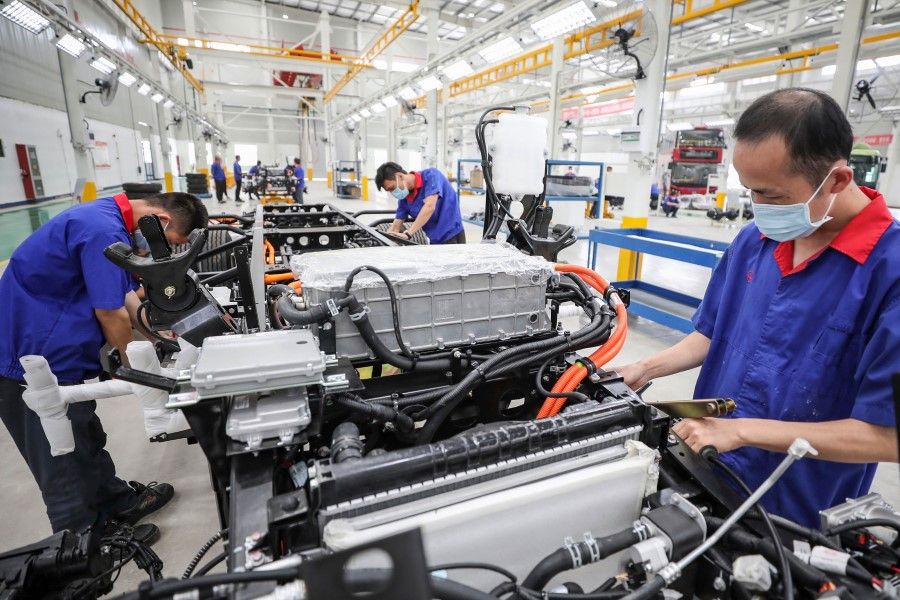 Employees work on a new energy vehicle (NEV) assembly line at a factory in Huaian in China's eastern Jiangsu province on 6 July 2020. (STR/AFP)