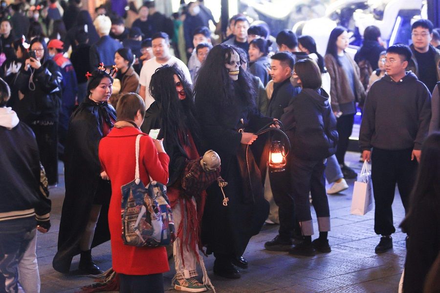This photo taken on 31 October 2023 shows people in costumes walking on a street during Halloween celebrations in Shenyang, in China's northeastern Liaoning province. (AFP)