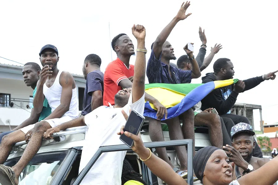 Residents gesture as they celebrate in Libreville, Gabon, on 30 August 2023 after a group of Gabonese military officers appeared on television announcing they were "putting an end to the current regime" and scrapping official election results that had handed another term to veteran President Ali Bongo Ondimba. (AFP)