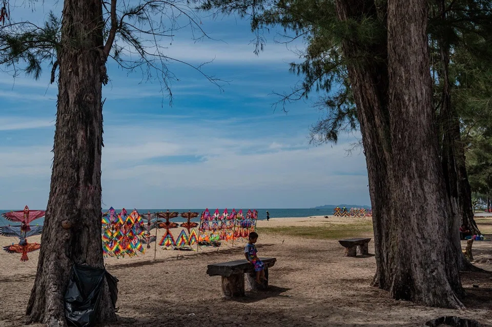 A boy sits on a bench on Batu Burok beach in Kuala Terengganu, in Malaysia by the South China Sea, on 26 June 2020. (Mohd Rasfan/AFP)