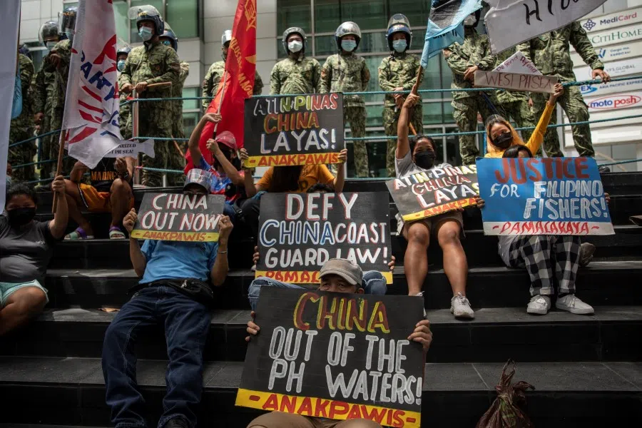 Activists stage a protest outside the Chinese Consulate, guarded by Philippine police, on the fifth anniversary of an international arbitral court ruling invalidating Beijing's historical claims over the waters of the South China Sea, in Makati City, Philippines, 12 July 2021. (Eloisa Lopez/Reuters)