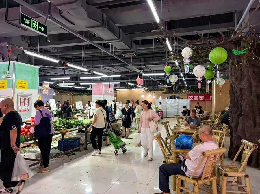 Shoppers visit the Jinyulai market in Xiaolongkan, Chongqing. The site of the market was originally a China Resources Vanguard supermarket, which was renovated after it closed.