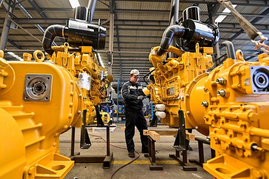 Employees work on an assembly line producing wheel loaders at a factory in Qingzhou, Shandong province, China, on 17 January 2024. (AFP)