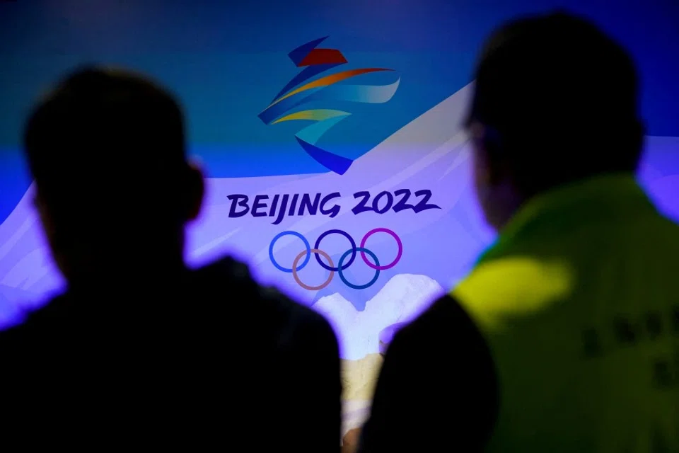 Staff members work near the emblem for Beijing 2022 Winter Olympics displayed at the Shanghai Sports Museum in Shanghai, China, 8 December 2021. (Aly Song/Reuters)