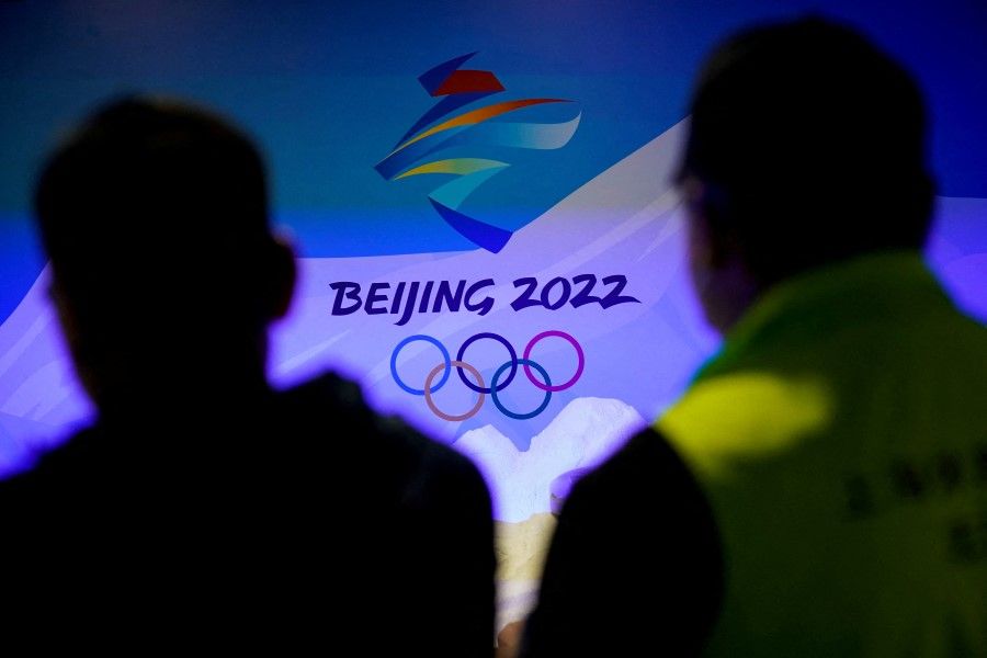 Staff members work near the emblem for Beijing 2022 Winter Olympics displayed at the Shanghai Sports Museum in Shanghai, China, 8 December 2021. (Aly Song/Reuters)