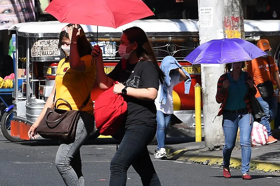 People walk in Manila, Philippines, on 29 April 2024. (Ted Aljibe/AFP)