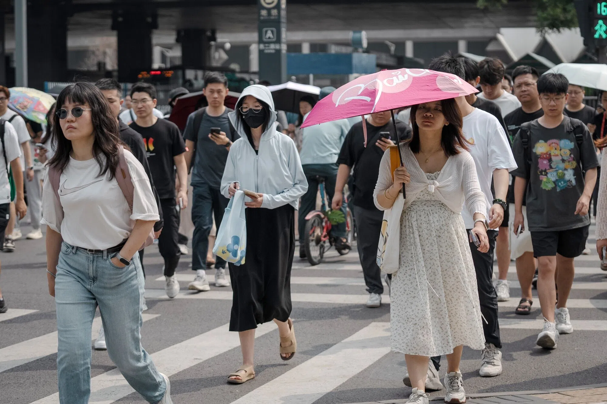 Pedestrians cross a road in Beijing, China, on 10 July 2024. (Na Bien/Bloomberg)