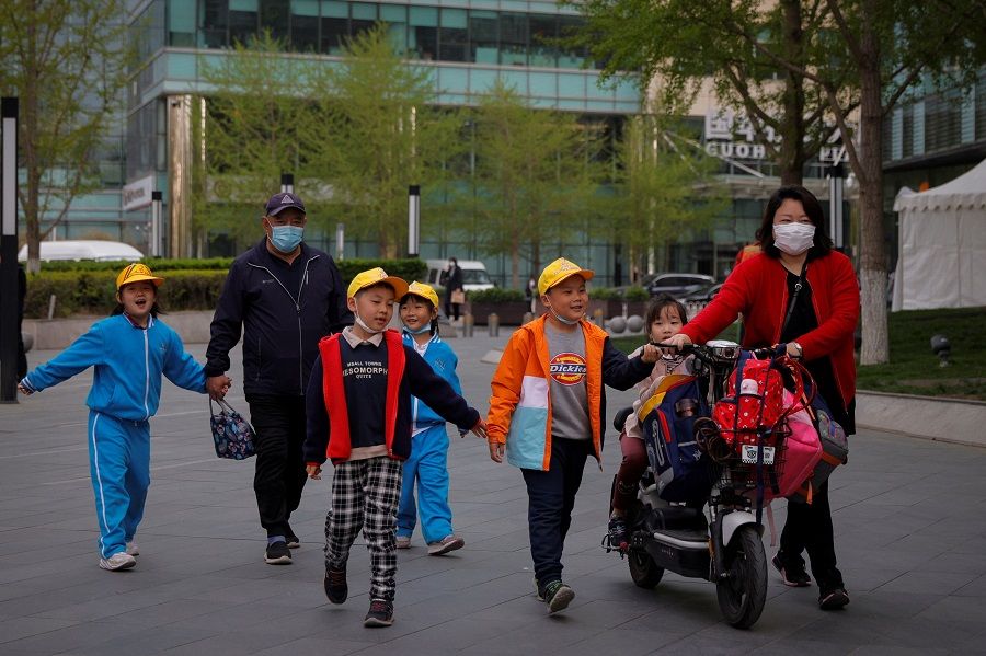 People pick up children from a school in Beijing, China, 6 April 2021. (Thomas Peter/Reuters)