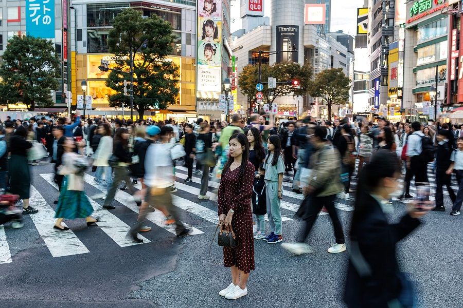 People pose for photos at Shibuya Crossing, one of the busiest intersections in the world, in the Shibuya district of Tokyo on 27 October 2023. (Philip Fong/AFP)