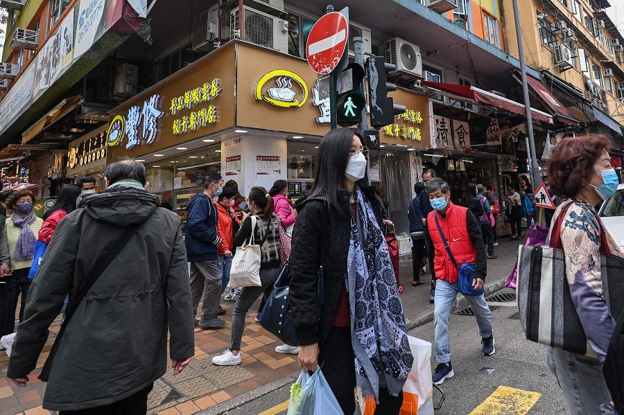 People walk along a street in the town of Sheung Shui in Hong Kong, China, on 4 January 2023. (Peter Parks/AFP)