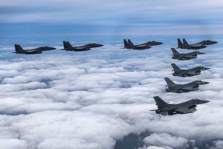 This handout photo taken on 4 October 2022 and provided by the South Korean Defence Ministry in Seoul shows four South Korean Air Force F-15Ks and four US Air Force F-16 fighters flying over South Korea, during a precision bombing drill in response to North Korea firing an intermediate-range ballistic missile over Japan. (Handout/South Korean Defence Ministry/AFP)