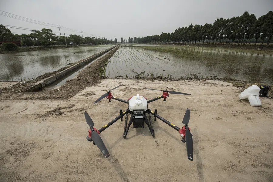 A pesticide-spraying drone waits to be loaded with batteries and payload at a newly planted rice field on Chongming Island in Shanghai, China, on 18 May 2020. (Qilai Shen/Bloomberg)
