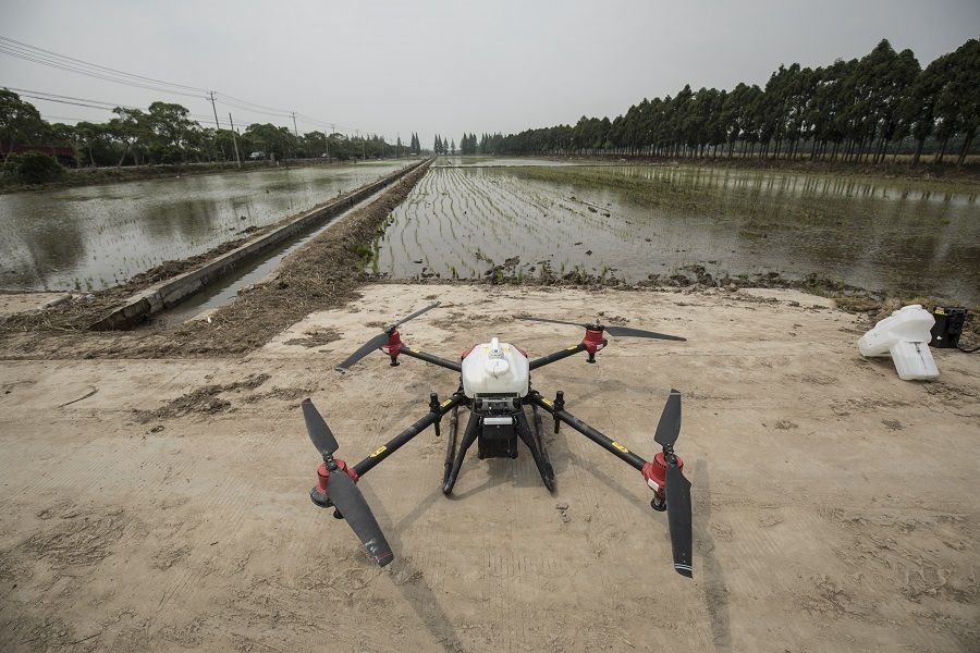 A pesticide-spraying drone waits to be loaded with batteries and payload at a newly planted rice field on Chongming Island in Shanghai, China, on 18 May 2020. (Qilai Shen/Bloomberg)