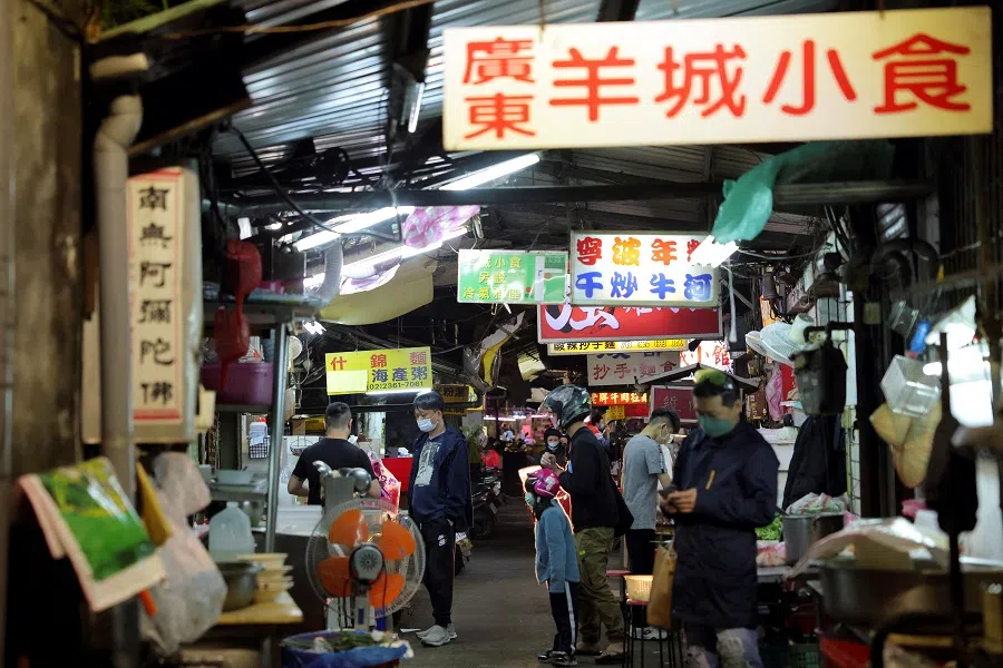 People wearing face masks to curb the spread of Covid-19 wait at a food stall in Taipei, Taiwan, 19 April 2022. (Annabelle Chih/Reuters)