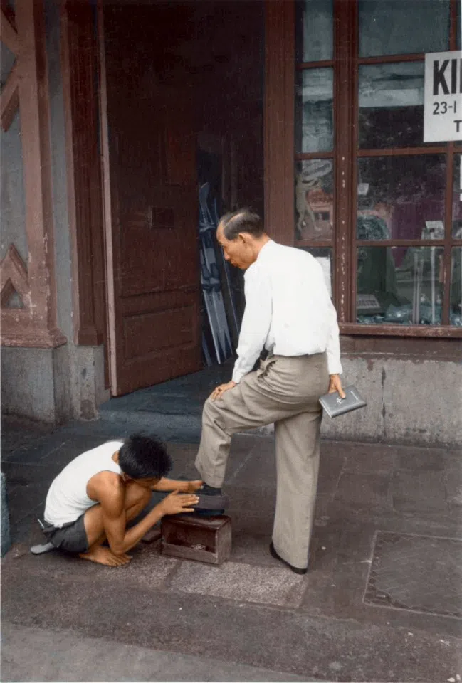 In the 1950s, shoeshine boys worked by the roadside. Unemployment and poverty meant inadequate educational support, forcing many school-age children to shine shoes to help support their families.