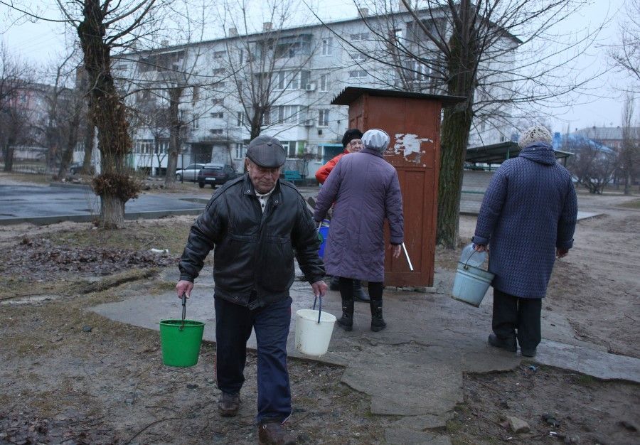 Citizens collect water from a well in the town of Schastia, near the eastern Ukraine city of Lugansk, on 23 February 2022, after the town's pump stations were knocked out of power by shelling. (Anatolii Stepanov/AFP)