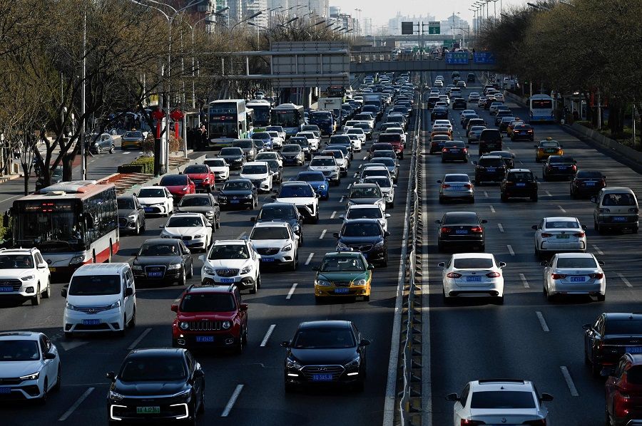 Vehicles drive along a street at the central business district in Beijing, China, on 16 January 2023. (Wang Zhao/AFP)