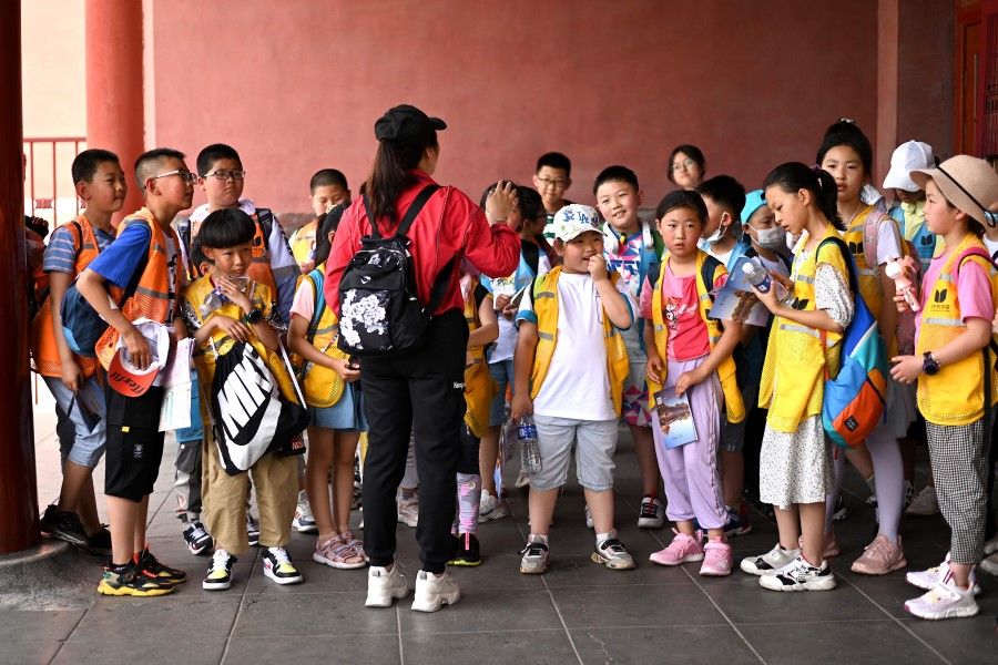 Children stand at the entrance of the Forbidden City in Beijing on 12 June 2021. (Noel Celis/AFP)