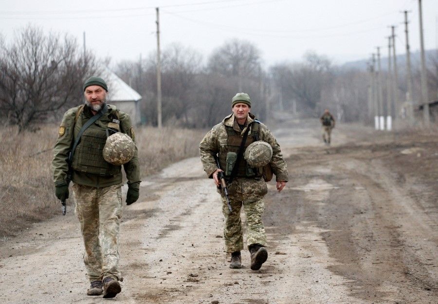 Ukrainian servicemen patrol in the settlement of Troitske in the Lugansk region near the front line with Russia-backed separatists on 22 February 2022, a day after Russia recognised east Ukraine's separatist republics and ordered the Russian army to send troops there as "peacekeepers". (Anatolii Stepanov/AFP)
