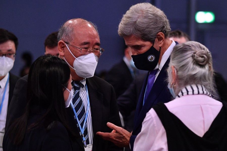 US special climate envoy John Kerry (centre right) speaks with China's special climate envoy Xie Zhenhua (centre left) ahead of a plenary during the COP26 UN Climate Change Conference in Glasgow on 13 November 2021. (Ben Stansall/AFP)
