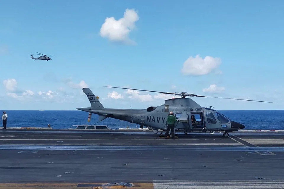This handout photo from the Armed Forces of the Philippines taken on 4 January 2024 shows a pilot executing a final check in a Philippine Navy AW109 helicopter on the deck of the USS Carl Vinson during the second iteration of the Armed Forces of the Philippines and the US Indo-Pacific Command Military Cooperative Activity in the South China Sea. (Handout/Armed Forces of the Philippines/AFP)