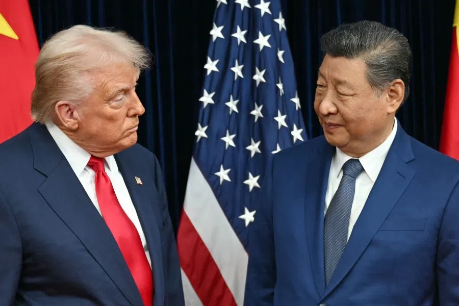 US President Donald Trump (left) and China’s President Xi Jinping greet each other as they arrive for talks at the Gimhae Air Base, located next to the Gimhae International Airport in Busan on 30 October 2025.