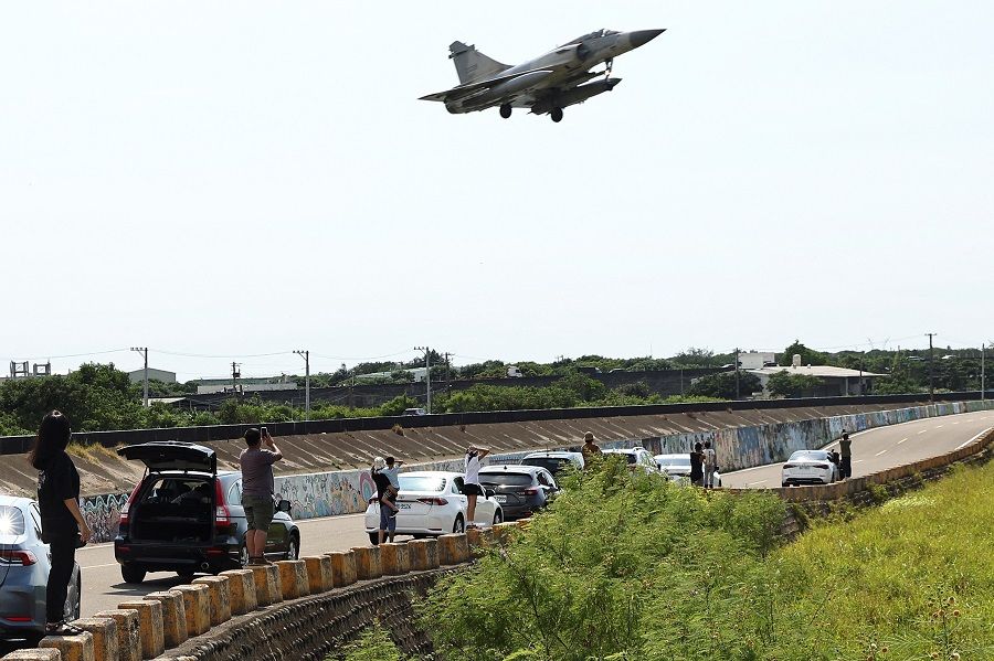 People watch as a Taiwan Air Force Mirage 2000-5 aircraft lands at Hsinchu Air Base in Hsinchu, Taiwan, 7 August 2022. (Ann Wang/Reuters)