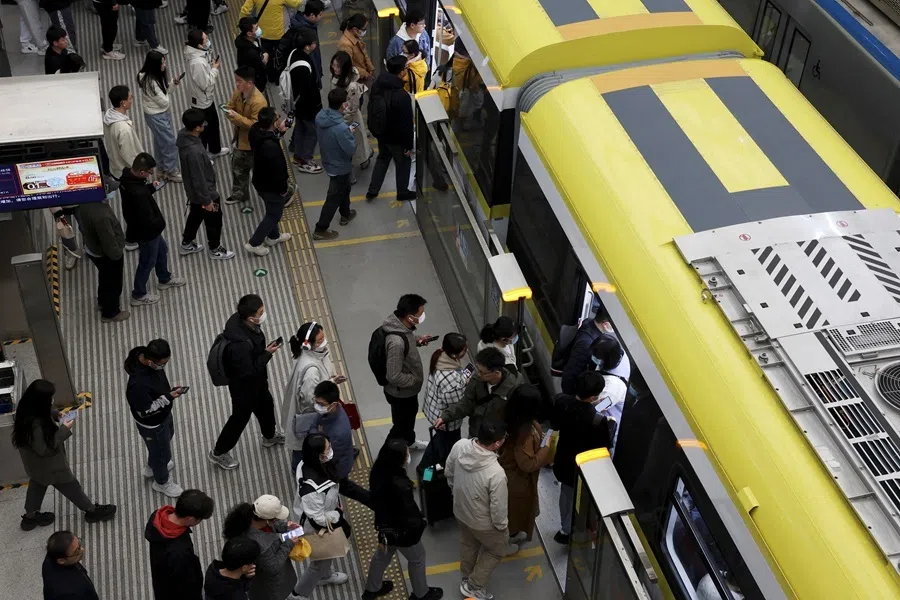 Commuters line up to board a train at a subway station near the Zhongguancun tech hub, during morning rush hour in Beijing, China, on 27 March 2025.