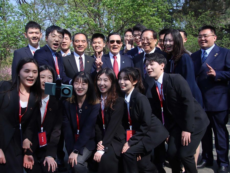 This handout picture taken and released by Taiwan’s Ma Ying-jeou Foundation on 9 April 2024 shows former Taiwan President Ma Ying-jeou (centre) posing for photographs with Peking University students in Beijing, China. (Handout/Ma Ying-jeou Foundation/AFP)