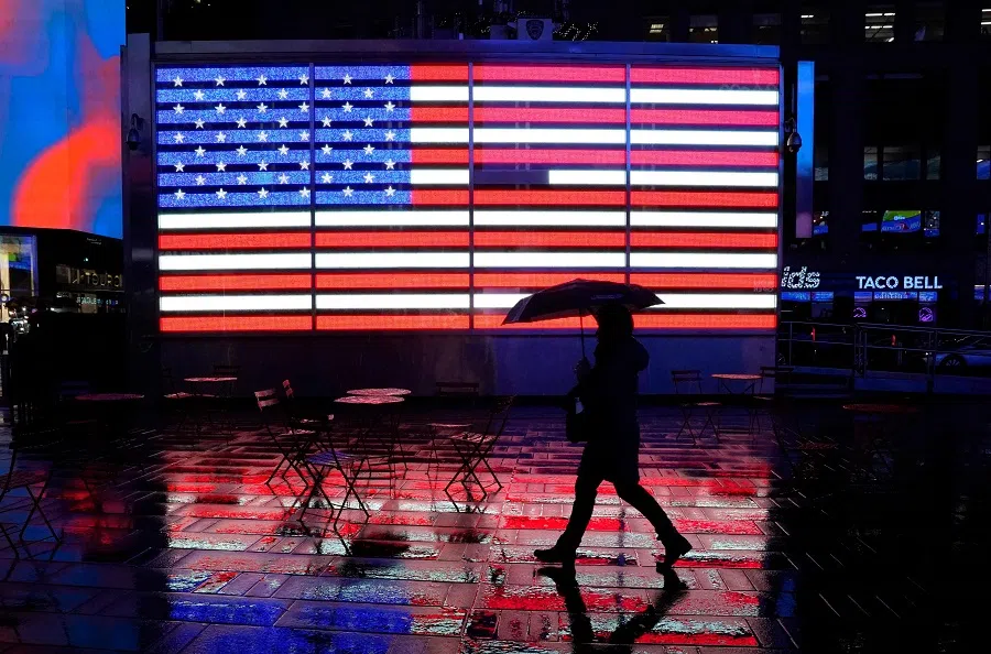 A person holds their umbrella as they walk through Times Square, New York, on 9 January 2024. (Timothy A. Clary/AFP)