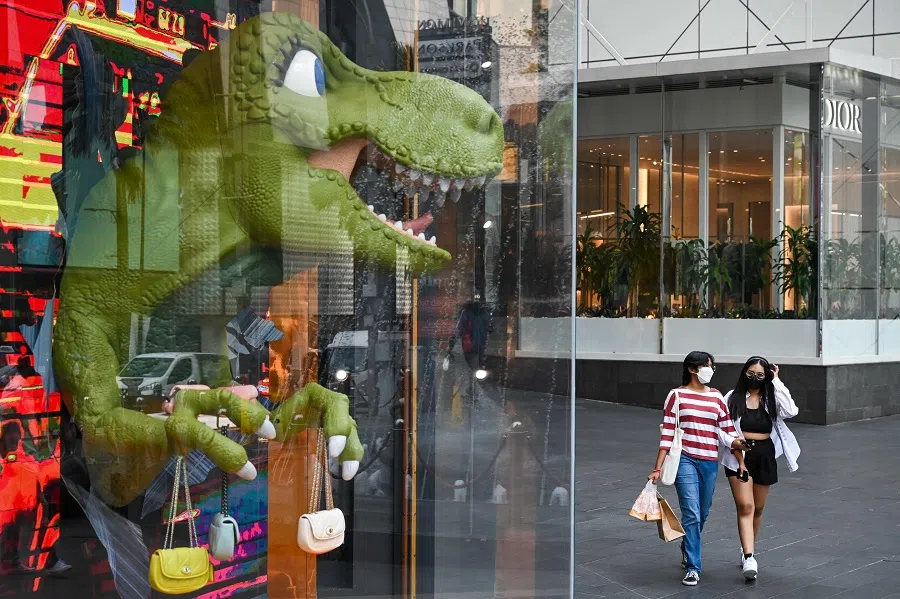 People walk past a shopping mall in Kuala Lumpur, Malaysia, on 2 June 2022. (Mohd Rasfan/AFP)