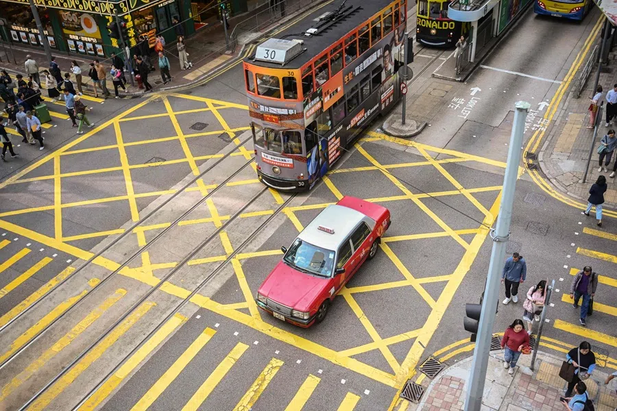 A taxi and a tram commute on a street in Hong Kong on 3 April 2025. (Peter Parks/AFP)