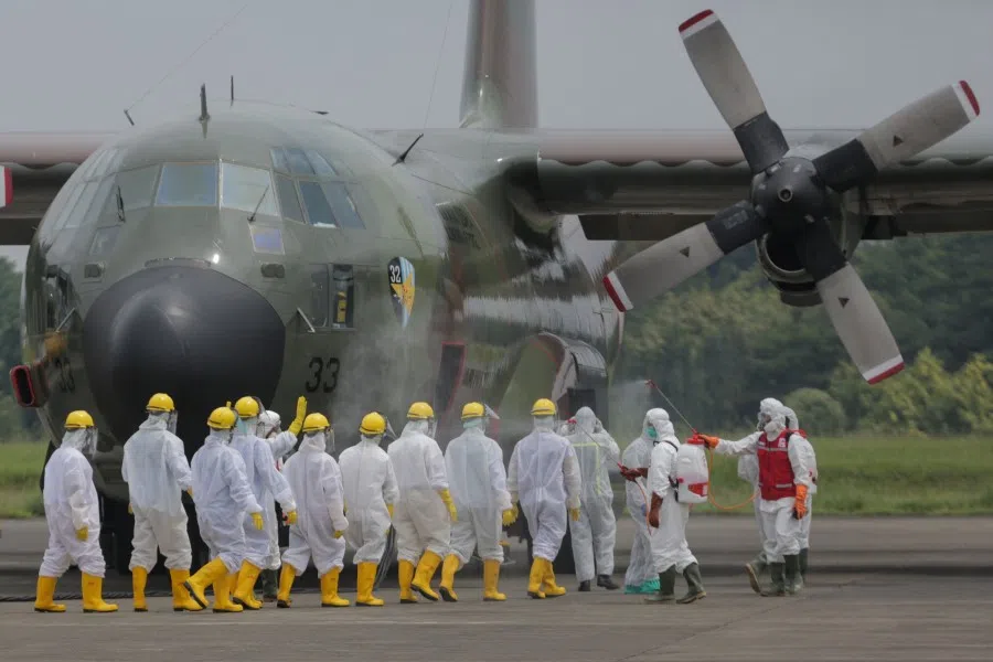 Indonesian soldiers and health officers prepare to move boxes of medical supplies from China's government into a truck at the Halim Perdanakusuma airport in Jakarta, March 23, 2020. (STR/AFP)