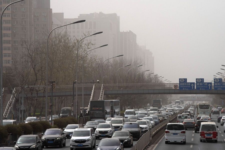 Vehicles travel on a road shrouded in smog during a sandstorm in Beijing, China, 22 March 2023. (Bloomberg)