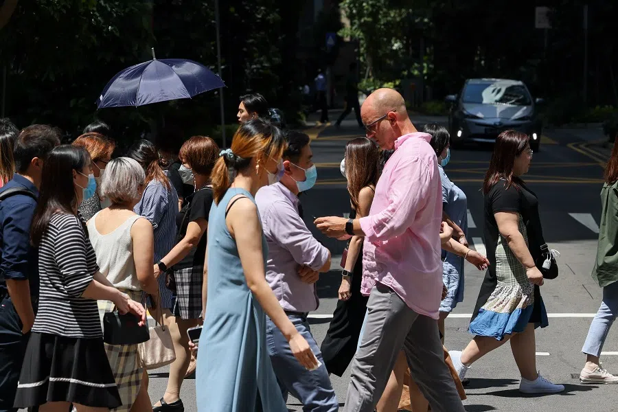 People cross a road in the central business district, in Singapore, on 17 August 2022. (SPH Media)